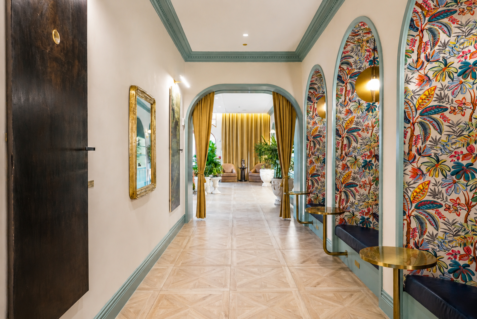 Lobby hallway — arched niches, tropical wallpaper, gold accents