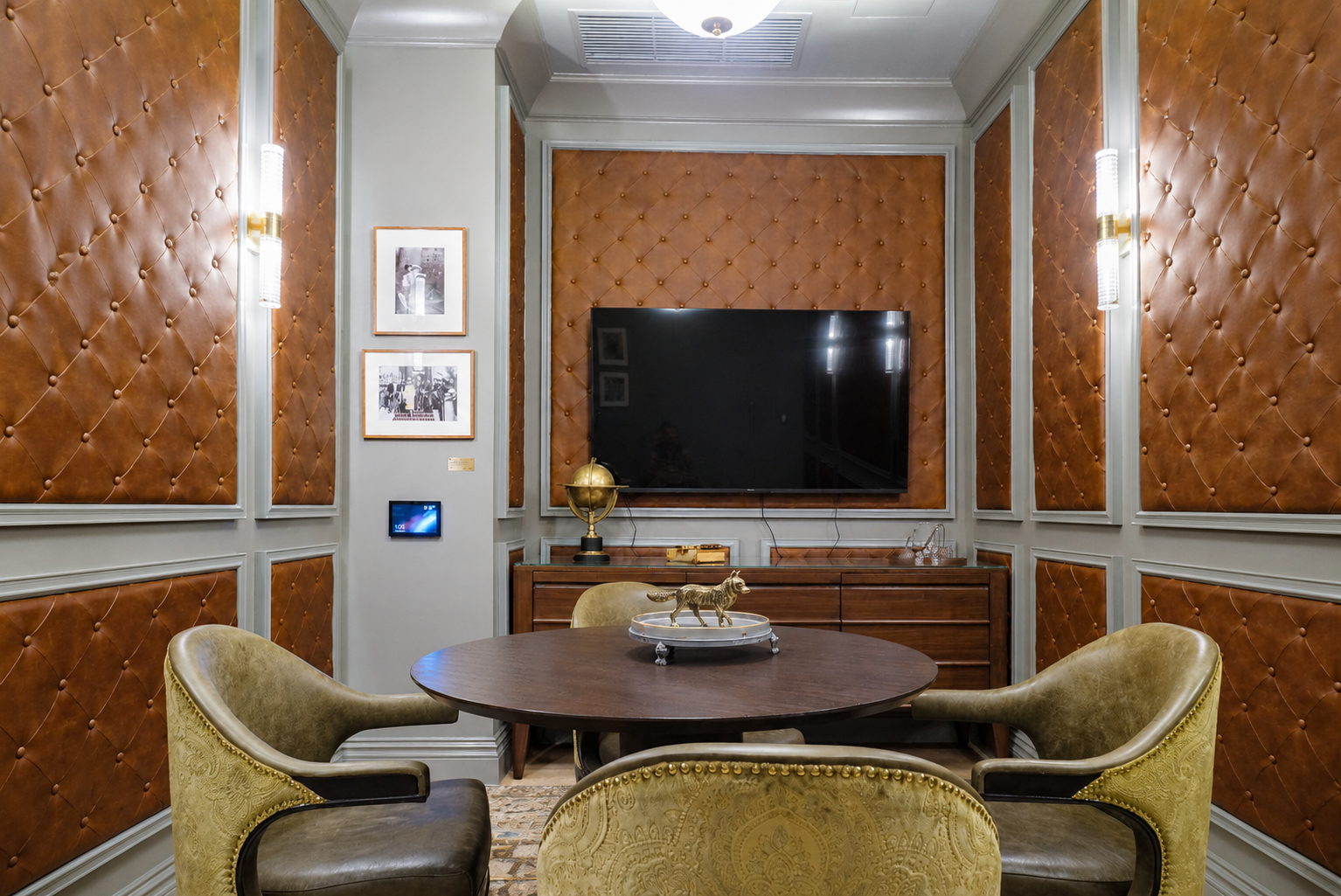 Screening room — tufted leather walls, round table, large screen