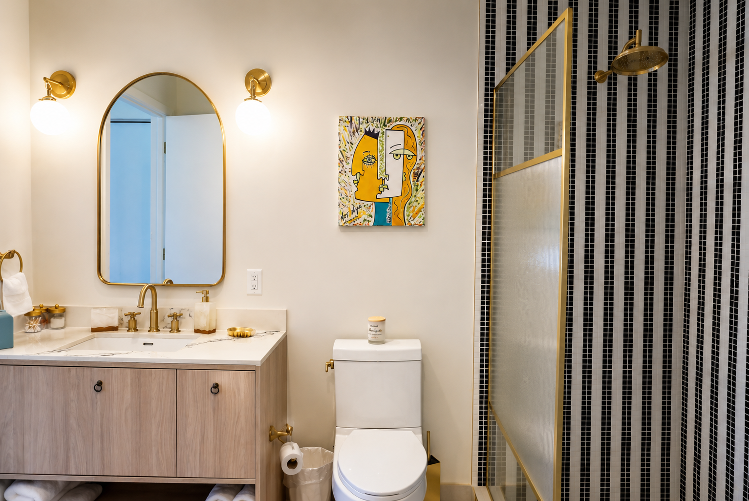 Bathroom — gold arched mirror, marble vanity, brass fixtures