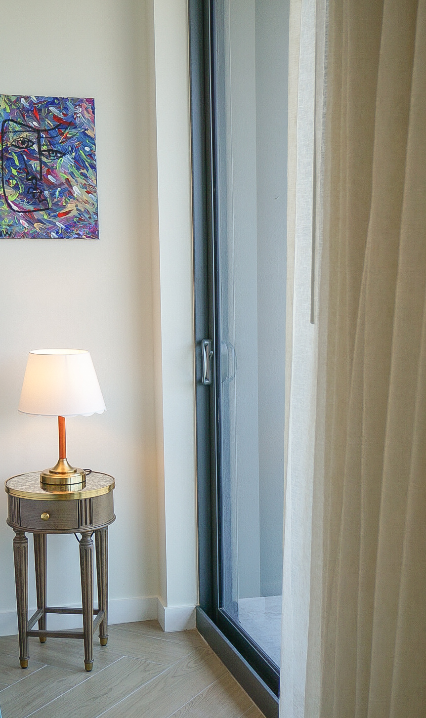 Bedroom nightstand — art lamp, sheer curtain, balcony light