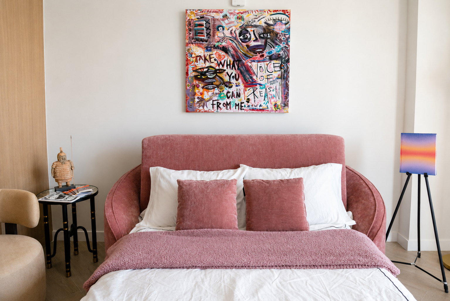 Bedroom with pink headboard and colorful art above