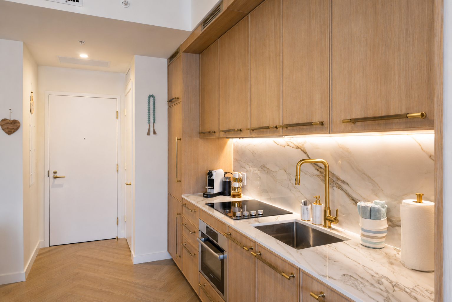 Kitchen from entry hallway — open plan with herringbone floors