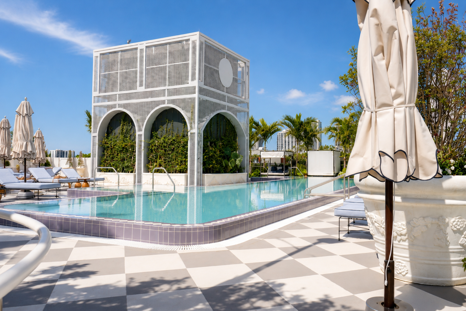 Rooftop pool — checkerboard deck, arched pavilion, blue sky