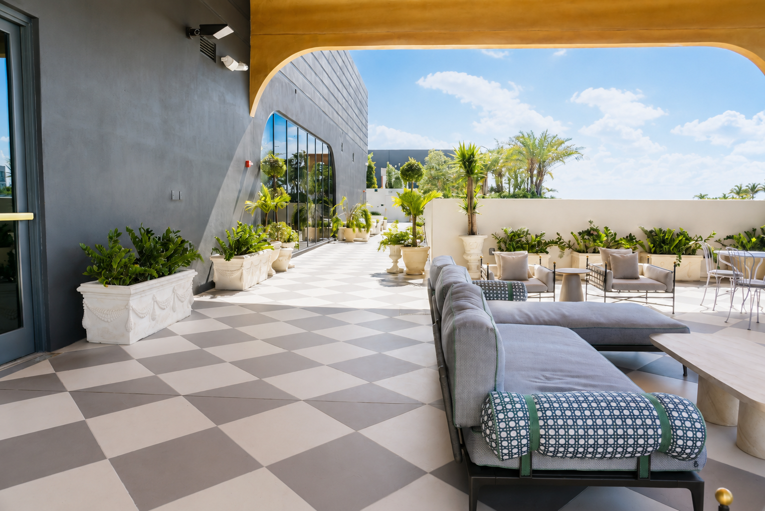 Covered rooftop lounge — curved gold canopy, sectional seating
